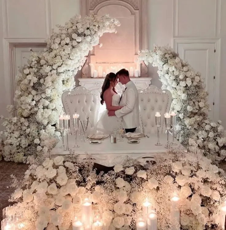 Sweetheart table with full floral styling and backdrop
